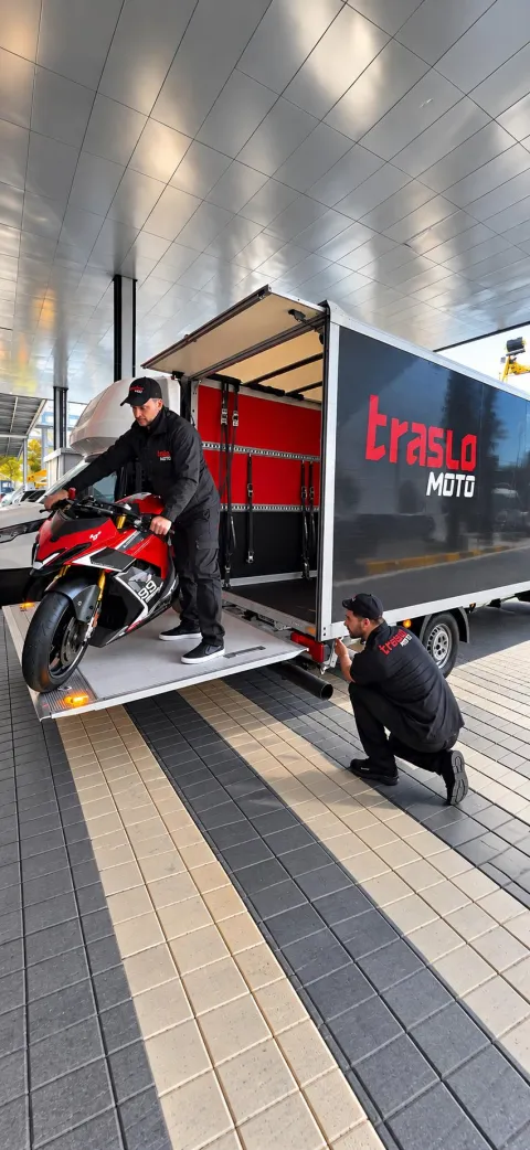 Due operatori TrasloMoto caricano una moto sportiva sulla sponda idraulica
