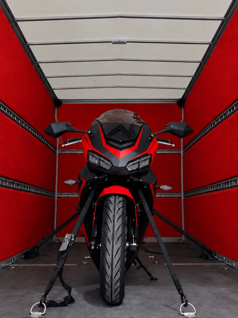 Moto ancorata con cinghie arancioni all’interno del furgone